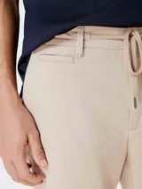 Bermuda color beige con cordón ajustable en la cintura y ruedo doblado.