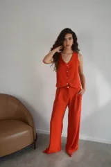 Conjunto de dos piezas color azul eléctrico, compuesto por un chaleco de manga corta con escote en V y botones frontales, y un pantalón de tiro alto con pierna ancha y pliegues.