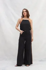 Pantalón negro de lino con corte jeanero, bolsillos plaque en la parte trasera y cintas marrones a contratono en los laterales.