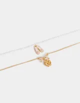 Collar corto multicadena dorada, con una cadena de eslabones y otra de perlas. Incluye dijes de zapatos de ballet rosados, moño y flor de metal dorados.