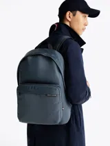 Mochila azul marino de poliéster con logo de Tommy Hilfiger en el frente. Cuenta con múltiples bolsillos, correas ajustables y acolchadas, asa superior y cierre de doble cremallera.