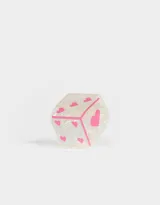 Broche de acrílico blanco con forma de dado y corazones rosas.