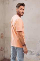 Remera gris con cuello redondo y mangas cortas. Estampado pequeño de dos patos en el pecho.