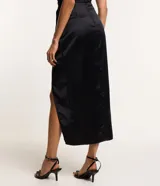 Vestido midi negro de satén con escote halter y abertura lateral.