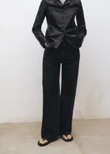 Pantalón de jean negro de corte recto, tiro alto y cinco bolsillos.