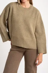 Sweater de punto color tostado con calce oversize, cuello redondo y mangas largas anchas. Presenta terminaciones acanaladas en cuello, puños y ruedo.