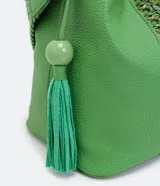 Bolso tipo bucket verde con correa transversal tejida, detalle trenzado en la parte delantera, colgante de borla y cierre con botón a presión.