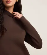 Sweater negro de punto con cuello redondo, puños y ruedo acanalados. Incluye cuello, puños y ruedo de camisa celeste a rayas.