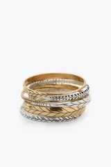 Set de pulseras rígidas doradas y plateadas con diferentes diseños labrados.