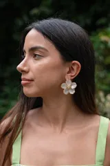 Aros colgantes con forma de flor de pétalos blancos y centro con strass, con detalles dorados.
