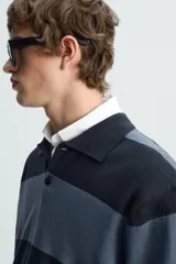 Polo relaxed fit de punto tejido en hilatura de algodón, a rayas horizontales en tonos azul y negro. Cuello solapa con cierre frontal de botonadura, manga larga y acabados en rib.
