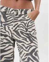 Pantalón de jean con estampado de cebra en tonos grises y blancos, de corte recto y tiro alto.