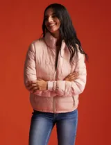Campera puffer reversible Michael Kors color rosa con estampado de logos MK en un lado y liso en el otro. Tiene cierre central metálico, bolsillos delanteros y avíos metálicos con logo. Incluye bolsa autoportante.