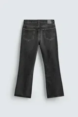 Pantalón de jean negro con efecto lavado, corte bootcut, tiro medio y cinco bolsillos.