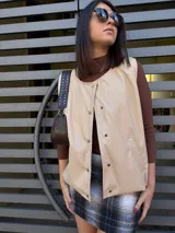 Chaleco color beige con botones y cuello en V.
