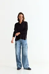 Cardigan negro de manga larga, con cuello camisero, botones frontales y un bolsillo en el pecho.