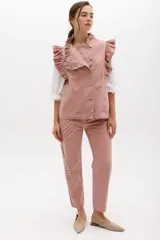 Jean gris lavado, estilo mom fit, con aplique fruncido en forma de espiral en la pierna izquierda, tiro alto, bolsillos delanteros y traseros funcionales, y cierre frontal con botón y cremallera.