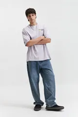 Remera de manga corta color lila, corte oversize, con cuello redondo y estampado pequeño en el pecho. Confeccionada en algodón.