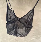 Top negro con transparencias y breteles regulables, diseño sensual y distintivo.