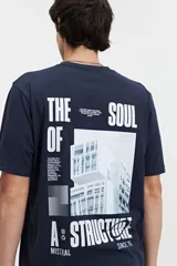 Remera azul marino de manga corta con cuello redondo. Estampado en la espalda con texto en blanco, imagen de un edificio moderno y logo de la marca Mistral.