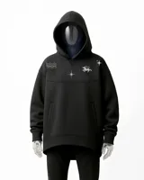Canguro negro oversize con capucha y bolsillos laterales. Presenta un diseño estampado en gris plata con motivos esotéricos: estrellas, constelaciones y un unicornio alado.