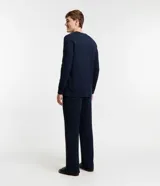Pijama largo de algodón azul marino para hombre, compuesto por remera de manga larga con cuello redondo y pantalón con cintura elástica y lazo ajustable. Presenta detalle de bies contrastante en color crema en cuello, puños y laterales del pantalón.