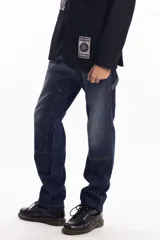 Pantalón de jean negro de corte recto, con refuerzo en las rodillas y detalles de costuras a la vista.