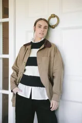 Campera color beige confeccionada en tela de algodón con cuello de pana marrón.