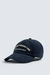 Gorra azul marino con visera y bordado frontal con la frase "Going Through Time Garden District, NOLA" en color crema. Ajuste trasero con hebilla metálica.