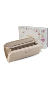 Billetera larga color mostaza con textura rugosa, cierre perimetral con deslizador metálico y placa rectangular con logo en el frente.