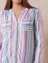 Blusa de lino estampada a rayas verticales de colores blanco, verde, lila, amarillo y rosa. Tiene cuello a la base con escote en V y abertura central con botones. Cuenta con dos bolsillos frontales y mangas largas regulables con presilla y botón. Marca Zac & Rachel.