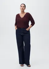 Jersey de punto fino color vino tinto, con cuello pico y manga larga. Tejido de lúrex con acabado brillante.