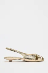 Sandalias doradas con tiras cruzadas en el empeine, tira trasera y tacón kitten heel.