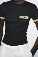 Camiseta blanca de corte slim fit, cuello redondo y manga corta. Detalle de acabados en tricot con hilo metalizado color dorado en mangas y bolsillo.