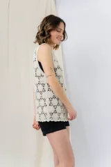 Chaleco tejido calado color crudo con escote en V y cierre frontal con botones.