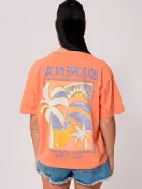 Remera color amarillo claro con estampado en el frente que incluye un sol y el texto 'Rusty Club'. Corte holgado.