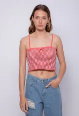 Top tejido color rojo con pequeños calados, sin mangas, tirantes finos y escote recto.