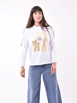 Remera blanca de manga larga con estampa rectangular dorada con diseño animal print y texto 'Fearless, fierce & fabulous'.
