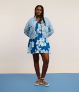 Campera de jean celeste de algodón con cuello inglés, abotonada, de manga larga ajustada con elástico en la cintura.