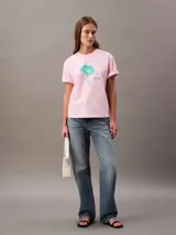 Remera rosa de algodón con cuello redondo y mangas cortas con dobladillo. Estampado de flor celeste en el frente y logo de Calvin Klein.