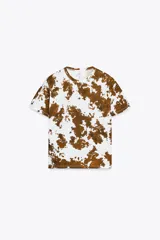Camiseta blanca con estampado de manchas marrones, cuello redondo y mangas cortas.