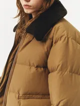 Chaqueta acolchada de color marrón con cuello de pelaje sintético.