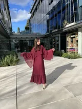 Vestido midi burdeos de breteles finos, con escote en V y volados en el ruedo.