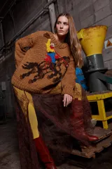 Sweater tejido de lana color marrón con bordado de un jinete a caballo. Tiene cuello redondo y puños acanalados.