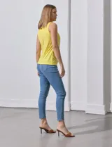 Blusa sin mangas color amarillo, con cuello redondo con frunces delanteros y abertura con botón en la espalda.