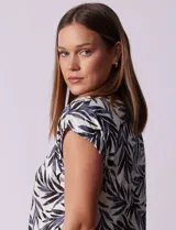 Blusa de modal con estampado de hojas en tonos azulados, escote en V con botones y ruedo anudado.