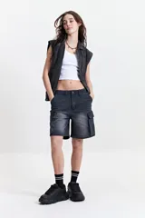 Chaleco denim negro con fit relajado y hombros caídos.