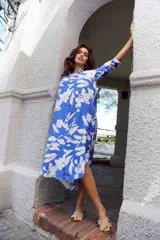 Vestido camisero midi azul con estampado de flores blancas, de manga larga y corte holgado.