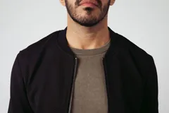 Campera tipo bomber de frisa color azul marino, con cierre frontal y bolsillos laterales.