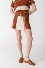 Minifalda marrón con paneles laterales color crema y rayas rojas y marrones.